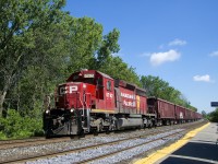 A CP ballast train powered by CP 5792 is passing the Île-Perrot Station. CP 5792 is one of the few CP SD40-2's to have a beaver on the long hood.