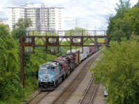 CP 250 is coming off the appropriately named Farnham Connection as it comes onto the Adirondack Sub for a run to Farnham, where a new crew will take over. Leading is CEFX 1002 in CMQ paint, which is passing under a vintage signal bridge.