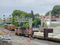 Counterparts and different generations of GE products meet as CN 305 with CN 2454 leading (built in 1992) passes a parked CN 306 which has CN 3135 leading (built in 2018).