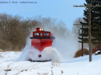 OSR's early March 2015 plow extra is westward on the St. Thomas sub in Beachville flanging the right of way before the next deep freeze. Foreman Jack Hyde who is operating the plow lifts the blades for the west switch Beachville, because if not those blades will hit the rail (ouch!). You can see the flow of snow has momentarily stopped onto the plow. Once they clear the crossing in downtown Beachville they'll lower the blades again. Notice how this late in winter so much snow has fallen it rests above the railhead no matter where you are? That's why they flanged, essentially digs a few inches below the railhead and clears the snow from either side of the rails. If it warms up and freezes it becomes ice and can cause lots of trouble, so they take no chances and flange just in case. Winter 2015 was notoriously bad, OSR must have ran two dozen plows that year, but in 2 weeks you'd hardly know there was any snow at all.. it was gone.