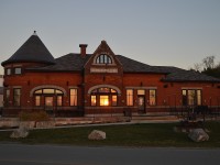 Always loved this station.
It was built in 1907, part of the Guelph and Goderich RR which was built by the CPR and before station was built the line was leased by the G&G to CPR for 999 years.
Last passenger train ran in 1956 and the last freight left in 1988.  The town of Goderich took it over. In 2013 over a three day period toward the end of July, this 400 ton structure was carefully moved to a new foundation just to the west a hundred yards or so, turned and facing the beach; and extensive renovations had it opening as the Beach St restaurant in June 2015. It is a beautiful place to visit, just gorgeous inside, and well worth the visit for a good meal as well.
I'm offering up this particular image as standing on a bench by the water gave a nice reflection of the setting sun in the windows, wrapping the station in a warm inviting glow.