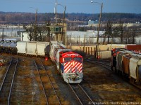 Pulling ahead to double onto their lift prior to departure, CN 376 passes an inbound train waiting at the yard control signals for permission to proceed. In the background is one of many yard towers found littering  the area - any folks familiar with Mac Yard care to educate me to what we're looking at? The winds were howling as I stood on the Highway 7 overpass for this shot and the sun was struggling to peek through in a brief break in the clouds between storms. <a href=http://www.railpictures.ca/?attachment_id=43401 target=_blank>30 minutes later</a> I'd capture them out on the mainline just as the 2'nd storm was about to hit.<br><br>Photo notes: Nikkor 80-400mm lens at close to 400mm