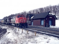 A typical dreary day in February and I find myself on a day off work hanging around the old Dundas station. It was a change from Bayview and presented some interesting scenery. And I always loved shooting trains with a station included, as it was stations that got me into this hobby in the first place.
So, eastbound is CN 9578 and 5046 with a long string of boxcars and mixed freight behind. A couple of passenger trains still stopped at Dundas station back then, so I was pretty well guaranteed the parking lot would be clean. 
 This image shot using Woolco slide film, and held up remarkably well.