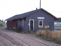 This rather sad looking building as photographed back in 1981 I am posting here just for those interested in Prince Edward Island and it's railroad history. It is not much to look at, but in 1981 it was an old freight shed converted to station. The way freights stopped here on their infrequent visits, crews and maintenance personnel used the building in which to do their paperwork. Curiously, there is a "VIA" decal on the door, yet passenger service ceased here in 1968. I'm guessing perhaps someone could stop in and order tickets for the bus out of Charlottetown?
Originally Souris had a passenger depot built between Souris East and Souris West, around 1876 as the town was divided by the wide and slow mouth of the Souris River. The station was built on a moving sandbar! Worse, tides affected the rails, and often sand covered them and had to be swept away. Such was the early days of the PEIR. A second station was built in 1879 on stable land in Souris East.
That station lasted until 1971 when vandals burned it to the ground. So the freight shed pictured was now "the station" in town.
Souris has been going thru troubling times. The population, just over a thousand, is declining. It was settled first in 1727; and early settlers had endless troubles with huge mouse populations. Actually, "Souris" is the French word for "mouse", and that little furry you-know-what is the town mascot.
The station, or whatever you want to call it, is now long gone.