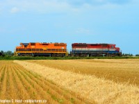 Near Seaforth, 581 trundles along the rickety rails of the Exeter subdivision as a farmer tills his field on a hot summers day, a true rural branchline. The sky looked like it wanted to storm, but it didn't.