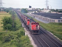 Once a familiar sight, the Dofasco Ore train has been gone since around 1990 when profitability ceased. The train I would think ran most often with 5 gp40-2L wide bodies; as seen here. We note CN 9529 as leader, I have no idea where my notes went on this one, so no numbers for the rest of the power other than the second unit visible. I shot this from the QEW bridge over the tracks, so maybe my paper blew away. :o) In the extreme background you can see on the right the old Freeman Station opposite where the 90 or so ore cars are coming off
the Halton sub. The train was handed to the CN from the ONR.
"A/C" door open..it must have been a warm day. I forget.