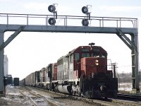 Rolling eastward under the old signal bridge that used to be almost beneath the Waterdown Rd overpass, is CN 5063, 4574 and 4560. Note a car in the siding at the Kirkelder Spray Mister building, known in recent times as the Aldershot Cold storage, until its demise about 10 years ago. Lead unit was sold and re-manufactured for service on the BNSF in 1999. The trailing GP9s went for CN rebuilding and renumbering by 1993.