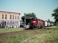 CP 5806 and 6019 power a westbound train thru downtown Chatham on a nice late summer day. The scene shows the crossing at William St.S.  (Judy LaMarsh building is out of view off to the right)  I have always liked this location for the open areas, good for shooting, and for that rather unique mural on the building on the left. Both SDs are now gone from the CP roster.