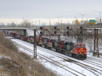 A long CN 527 has five units (CN 3836, CN 2952, CN 2190, CN 3086 & CN 9677) as it ducks under a signal bridge on the approach to Taschereau Yard. This angle just opened up recently when a large amount of bushes and trees were cut here.