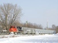 Empty potash train CN 731 has 227 cars and about half of them are empty grain cars as it passes the St-Henri station name sign. Up front are new CN grain cars, with older ones further back. Power is CN 8822 up front, CN 2129 mid-train and CN 8003 on the tail end.