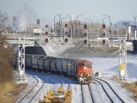 Empty grain train CN 875 has just left Turcot Ouest with a new crew onboard as it passes underneath a pair of signal gantries. This train has CN 2532 up front, CN 8883 mid-train and 187 cars.