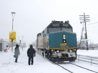 A pair of station attendants have just completed a snowman as they greet the arriving VIA 62 at the end of a snowstorm.