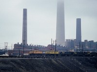 Back in the days of the INCO Electrics, we see motors #123 and 126 rolling past the landmark chimneys of Copper Cliff back in 1985. The barren lands of Greater Sudbury have been considerably cleaned up since these rather dirty times, and green vegetation has returned to the area.
Diesels were introduced to INCO and electrification ended in 2000. Most units scrapped, inc the two shown.
Motor #123 and 126 are both 85T units, built in 1942 and 1950 respectively and purchased for operation in the sprawling Sudbury area complex in 1971 from Kennecott Copper.