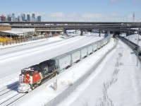 Snow-covered CN 8894 is the leader on CN 875 as it approaches Turcot Ouest, where it will get a new crew. IC 2707 is mid-train on this 218-car long empty grain and potash train.