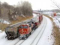 CN 100 unit CN 3879 brings up the rear of CN 120 as it passes a small cut of grain cars.