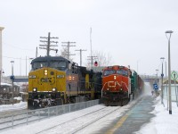 CN 305 is blasting by a CN 327 which is stopped in front of Dorval Station on a cold and windy afternoon. With CN 149 not too far ahead with engine problems and a number of VIA trains in the mix, CN 327 will be cooling its heels here for a little while before being able to continue westwards.