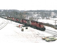 It is the deep dark days of winter, but no matter how crummy the weather there is always a train to be found. Unlike some fans, I enjoy shooting in any weather. There are more moods than "sunny ways".
Here, on yes, a crummy day; the TH&B starlite (or, starlight, if you prefer) is Hamilton-bound with a nice mixture of power: CP 5539, 5734, 8745, 8146 and TH&B 77, 54.
In the distant background I notice the tall smokestack. That is of the old landmark that used to be out in Aldershot, before it was razed for new homes. The Burlington Brick Company.