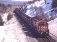 CP's reliable workhorse GP38-2 locos #3100 and 3089 are seen on the hillside along Highway 144 a few miles south of namesign CP Levack with a load of empties for the mine at Onaping Falls/Levack on a warm spring afternoon. This is around the perfect time of the year for photos up in the Greater Sudbury region in my opinion. Usually some snow to cover the dull grounds of early spring, but often warm enough to shed the winter coat. And NO bugs.
(The location of this photo is approximately opposite of a scenic spot called "high Falls")