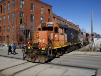 Two crewmembers have just gotten back on CN 4729 after flagging Charlevoix Street. Their train had just dropped off six grain cars at Ardent Mills. The building behind was once a Stelco factory and is now condos.