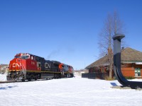 CN 324 with CN 2198 & CN 2528 is passing the ex-Grand Trunk station in St-Jean-sur-Richelieu. At right is an oversized spike to commemorate how this was the terminus of Canada's first railway (the Champlain and St. Lawrence Railroad).