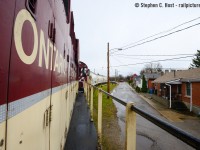 As a gentle rain falls, flanges squeal in protest as OSR shoves loaded cars of clay around the north leg of the wye toward Owens Corning Fibreglass in Guelph. Passing these unique homes on Sackville St, you'll note there are no front yard, just the street and the railway property which is basically their front yard. Trains passed here almost daily when the photo was taken and no one cared to watch the train as it passed on this damp fall day. Trains still use this track today but far less frequent, and homes (a year ago) on this street were selling for $399,000............ cheap by today's standards.