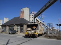 After lifting a long string of grain empties from track PC-27, the Pointe St-Charles Switcher is shoving back to its namesake yard, with a beat up caboose leading. The building at left dates to 1887 and was built as a pumping station to help avoid spring flooding in the port area. It bears the same name as the road the caboose is crossing, Riverside. Behind it are numerous mills and grain elevators. 