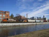 After lifting grain empties from Ardent Mills and putting them in a siding, the Point St-Charles Switcher is shoving loads towards the mill, visible at far right. The smokestack in the middle was part of a Stelco factory that once operated here.