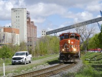 The Pointe St-Charles Switcher has left the Port of Montreal and is heading back to its namesake yard with four cars as it passes a foreman. Where the foreman is parked once had a couple of tracks that were used for runaround moves.