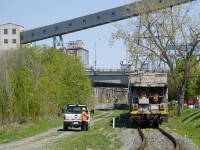 The Pointe St-Charles switcher is returning from switching a couple of clients, with a shoving platform leading back to the yard. A couple of crewmembers wave at a foreman who had just removed a red flag and derail on this section of track.