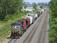 CN 527 has a long train and Dash9's in two paint schemes (BCOL 4649 & CN 2564) as it slowly approaches Taschereau Yard with a long train. It will have to cool its heels a bit before being getting its signal to enter the yard. The third car is a large boiler from Indeck in St-Hyacinthe.