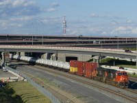 CN 3122 (ex-GECX 2033) & CN 5726 are the power on CN 401 as it emerges from out of the Turcot interchange. Up front are 3 intermodal platforms, followed a by a string of recently refurbished and repainted TankTrain cars. 