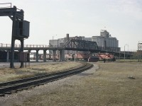 Here's a rather rough old image which I feel might appeal to those who knew and photographed at the Junction area of West Toronto in past years.
The whole of the long-gone old Weston Road bridge can be seen.
No traffic on it as it was closed a couple of years before this image was taken. Demolition was in 1983.
I had just gotten out of the car when a train rolled eastbound so grabbed this shot. Power is CP 5731, 4715, 4725, 5511 and 4709.  Best combination I would see this visit, and I almost missed it. Not much of a shot, but it is all now history.
That big grain facility that takes up so much land back there. Is that Campbell's Milling? I understand the structure was razed around 1992.  The area has all changed.