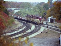 A nice, but overcast fall afternoon (all afternoons were nice when the TH&B was sighted) sees the TH&B starlight Hamilton-bound with TH&B 75, 402 and 76 providing the power. String of empties for TOFC up front. Old time scene shows steam-era (later MoW) helper track still in place; new walkbridge devoid of rail buffs; the old 'Bayview' sign is still the wooden version.......no idea who the photographer is down by the shed.