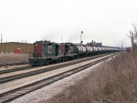 Gloomy day, but I am used to days of this kind. CN 4575 and 4520, both Geeps based out of Fort Erie, haul a unit GATX Tank Train westward past the Merritton station, destination unknown. With just two GP9s in charge, we know
the tank cars are empties.
I don't know anything about these cars, as to whether they are still used around the province or not. Just on short runs, I would assume. Do recall a cut of similar cars in an eastbound CN at Copetown a few months back. Have seen a solid train of this type only a couple of times over the years.