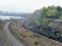 For me, this image is powerfully nostalgic.  For it is a CP detour train, running down from the GALT sub into Hamilton and back out to Toronto via the CN on account of the big Nov 1979 train derailment in Mississauga. Over 200,000 people were evacuated as tank cars threatened to blow; and it would be the single most intense derailment in Canada's history in terms of mass evacuation.
Anyway, after this train wound its way down the hill from Waterdown, I ran across the roadway and grabbed this image as it rolled up to the area known on CN as Hamilton Jct. The power on this train was impressive.
CP 8679 leading followed by C&O 3046, 3006 and 3532. Loved seeing GP30s.
Added note: A few years previous, I think 1975; there was a wooden bridge over to York which crossed the tracks, from Valley Inn Rd. It had a rather severe load limit.  A "not too bright" truck driver ignored the sign, and as a result the bridge collapsed.  You can see the concrete remains on the right hillside. And straight ahead of CP 8769 in the distance the CN section shack and 'Hamilton Jct' sign can be seen.
The CN "Cowpath" is on the left, which is the link to the Dundas sub and West from Hamilton.