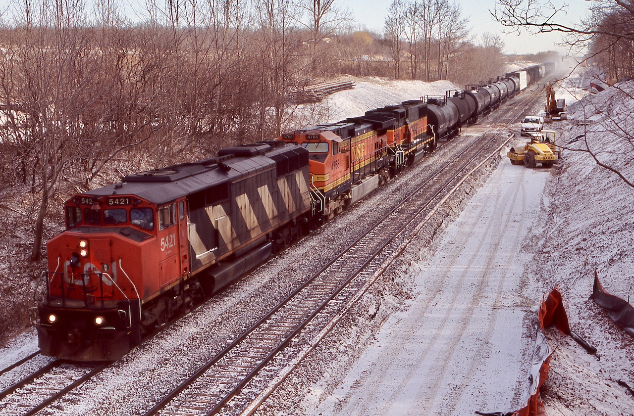 The rebuilding of the new plant at Snake was well under way as CN train 399 cautiously rolled by. The SD50's were nearing retirement by this time and BNSF power on this train was almost the norm, although the GP60"B"s were somewhat rare. New track sections can be seen off to the left up on the hill.