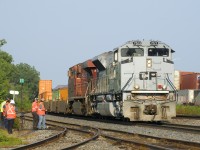 CP 143 is stopped in Dorval due to issues with the leader (Air Force unit CP 7023) as crewmembers and shop forces look on. After more delay and having to set off a car, the train would continue to Smiths Falls where further problems with CP 7023 would cause it to be moved to trail position. At right are two stopped intermodal trains on the CN Montreal Sub (CN 108 & CN 186).