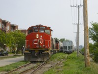 After picking up grain empties at Ardent Mills and leaving them in the siding at left, the Pointe St-Charles Switcher with CN 4808 & CN 4771 for power is about to couple onto the loads (at right) and shove them towards the mill. 