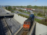 CN 522 is leaving Southwark Yard and taking the Rouses Point Sub to reach St-Jean-sur-Richelieu as it crosses Route 116 with CN 4795, GMTX 2257 and 13 cars. 