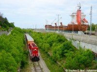 Trillium Railway (GIO Rail) southbound on the Canal sub with empties from Clearwater Paper of St. Catharines. To the right,  NEAS (Nunavut East Artic Shipping) MV Kamutik has just entered lock 7 of the Welland Canal enroute to Iqaluit Nunavut in the far far north of Canada, a journey that will take over a month. You can see the 'gate' for the lock are still up.. about to go down while they lower closer to Lake Ontario. I think it's appropriate we're seeing the rear of both modes of transportation :)