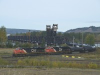 A CN oil train, led by 3051 and 3130 is seen heading southbound, crossing the "mighty" Fraser river. We stopped at the modernistic VIA station in Prince George, and the VIA "Skeena" (Prince George to Prince Rupert) was still sitting west of the station and the waiting room was full of passengers. The train should have left 35 minutes earlier, but CN once again annoyed the passenger service by leaving this oil train, blocking the Skeena.  We knew the CN would be pulling out soon, so went looking for a good vantage point for a photo and came up with this location on the east side of the river. The train is seen heading south to Vancouver after coming off the bridge. The line in the foreground is part of the way that connects to the line going off to the right, which heads to Edmonton.  Quite the bridge !!