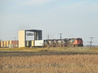 Well, here is something different. An Automated Car Inspection Portal.
This curious looking box-like structure is located about a mile west of the village of Ste Anne in Manitoba. It is one of two in operation; the other being in Winnipeg.
The machine is filled with LED lights and high-definition cameras that instantly capture a 360 degree view of each car as it rolls thru at track speed; around 60 MPH. Rather than manual inspection of rail cars that can take a couple of hours each by CN employees, this machine does the job in seconds, picking out any defective cars as the train passes.
Heading toward Fort Frances Ontario from CN's Winnipeg Symington Yard is eastbound CN 2990, NS 9887 and 1214.