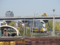 VIA 67 is passing a pair of dwarf signals at Cape, with the one at left showing a Slow to Clear indication for nearby VIA 62. Up above, work progresses on the REM light rail project. A bit to the left two catenary supports from a much older and long out of use electrification project still remain. CN passenger trains through here were electrified from roughly 1940 to 1960.