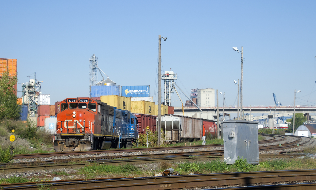 CN 4795 & GMTX 2257 shove boxcars and hoppers into Ray-Mont Logistics. At right are the two tracks of the Montreal Sub where VIA trains go to or from Central Station.