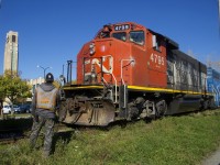 The conductor looks on as CN 4795 is about to couple onto some grain cars on the East Side Canal Bank Spur. At left is the clock tower of the Atwater Market, which opened in 1933.