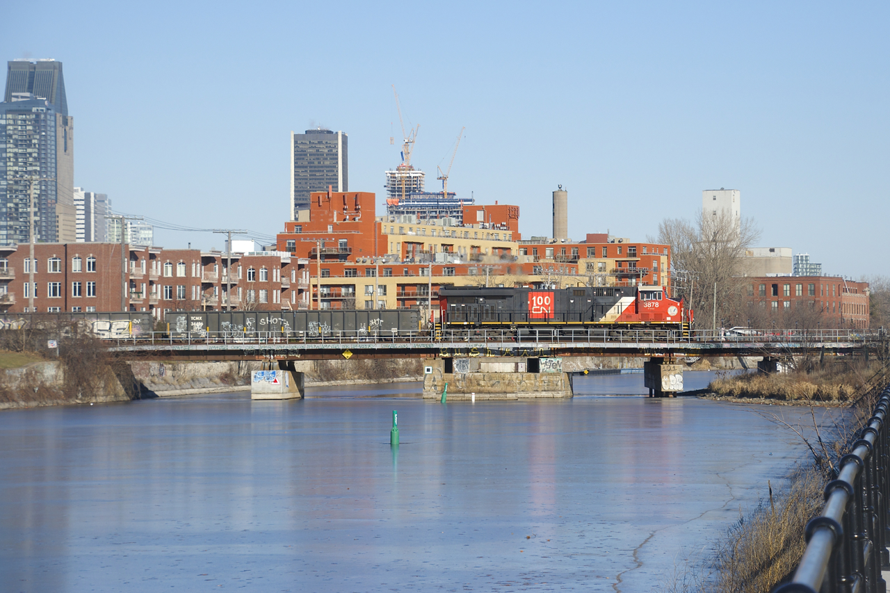 A CN 100 unit is leading CN 322 over the Lachine Canal. On the tail end is CN 3255; normally this train has a DPU on the tail end after it sets off cars at Taschereau Yard. It will terminate at Soutwark Yard.