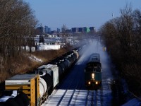 VIA 67 is kicking up snow as it passes some cars parked on the Freight Track of CN's Montreal Sub.