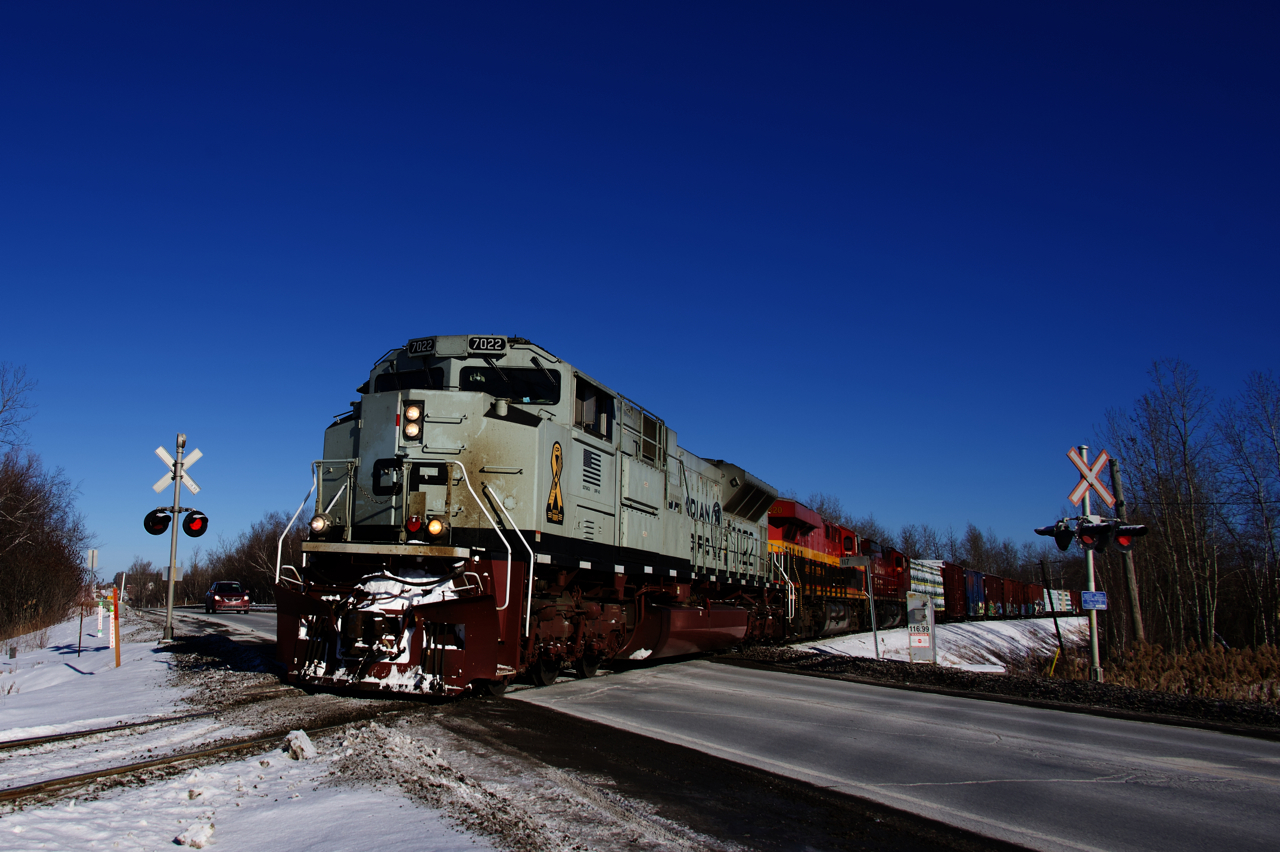 CP 251 is passing a crossing at MP 117 of CP's Sherbrooke Sub with a stellar lashup of CP 7022, KCS 4820 and CP 8107.