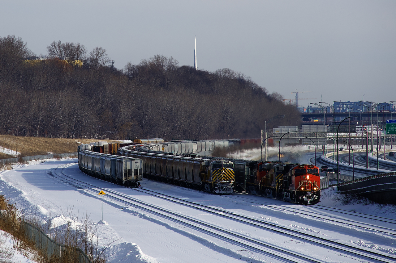 CN 305 with CN 2972, CN 3936 and CN 2597 arranged elephant style is passing the tail end of CN B730. On the tail end of CN B730 is ex-CREX unit CN 3986. At far left on the Freight Track are cars left by a CN 306 that had DP issues.