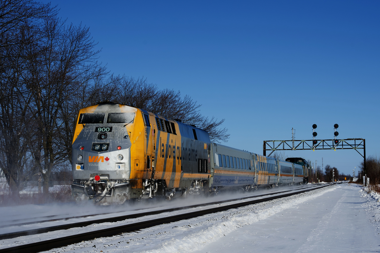 Class leader VIA 900 brings up the rear of VIA 62 as it approaches a vintage signal bridge. It is showing a Medium to Clear signal for VIA 62, which will bring it to the South Track, with CN 149 coming on the North Track.